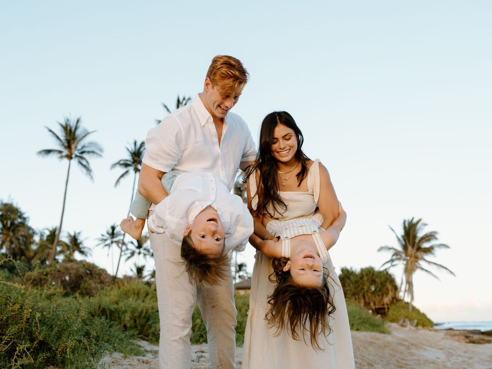 A family photoshoot by Moments With Kell on Oahu in Hawaii with family playing on the beach