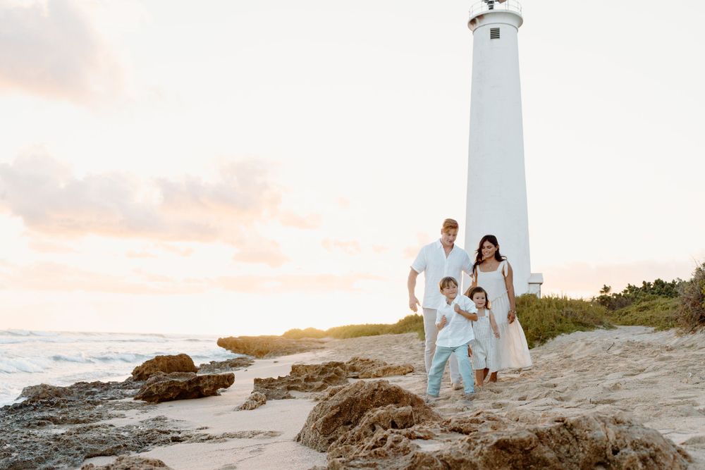 A family photoshoot by Moments With Kell on Oahu in Hawaii with family smiling on the beach