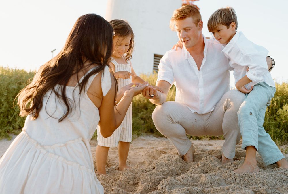 A family photoshoot by Moments With Kell on Oahu in Hawaii looking at shells on the beach
