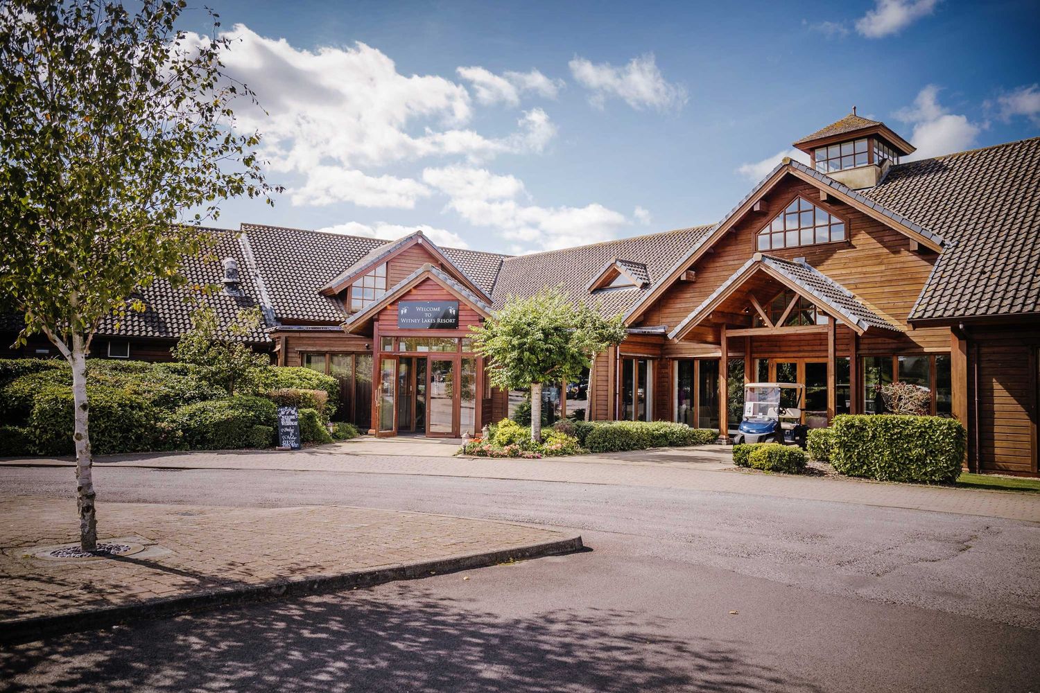 Large rustic lodge-style building with timber frame architecture and brick facade.
