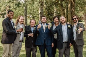 Wedding party poses for fun candid shots while enjoying themselves in a natural outdoor setting.