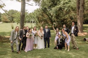 Casual wedding group shot showing natural interactions among party members outdoors.
