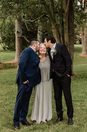 Sweet candid moment between family members during outdoor wedding photography session.