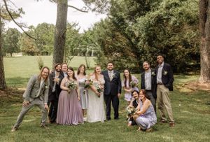 Wedding group creates casual portrait series in scenic outdoor garden location.