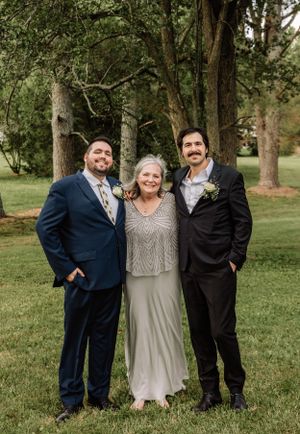 Candid wedding photo captures joyful interaction between family members outdoors.