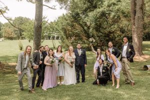 Candid moment of wedding party celebrating outdoors with joyful expressions.