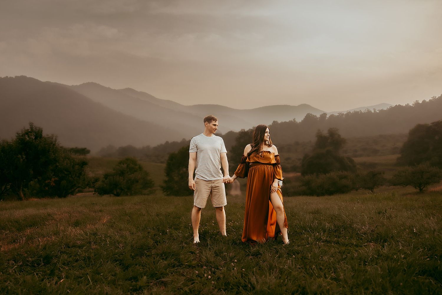 A husband and wife walk hand in hand during their Charlottesville Maternity Session.
