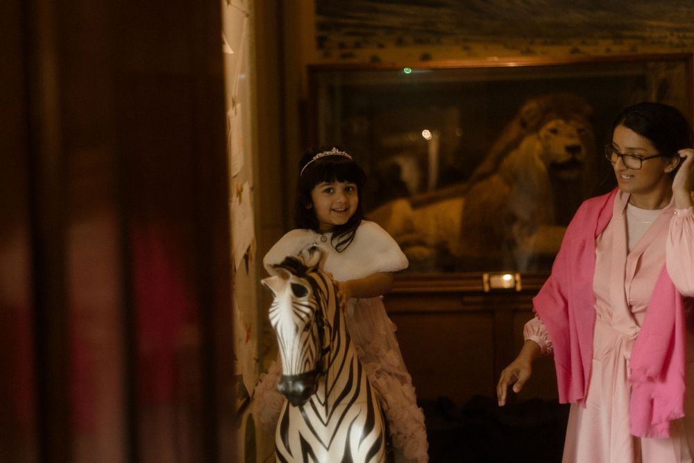 Interior scene with zebra statue and people in casual attire.