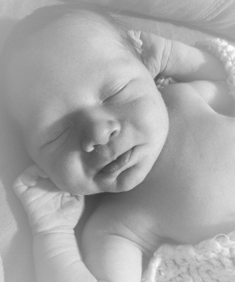Close-up black and white portraits of sleeping newborn baby.
