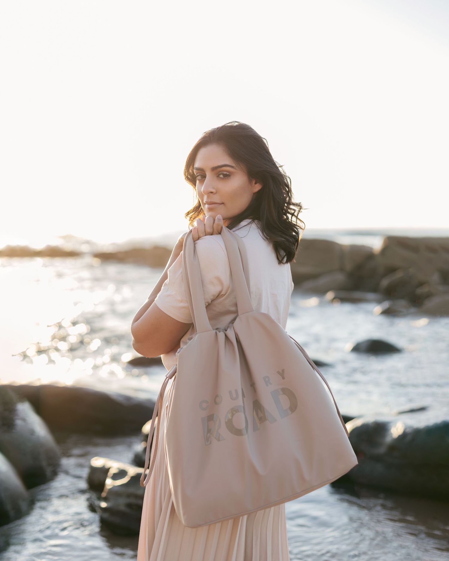 <img src="countryroad.png" alt="model on beach in golden hour backlighting holding bag">