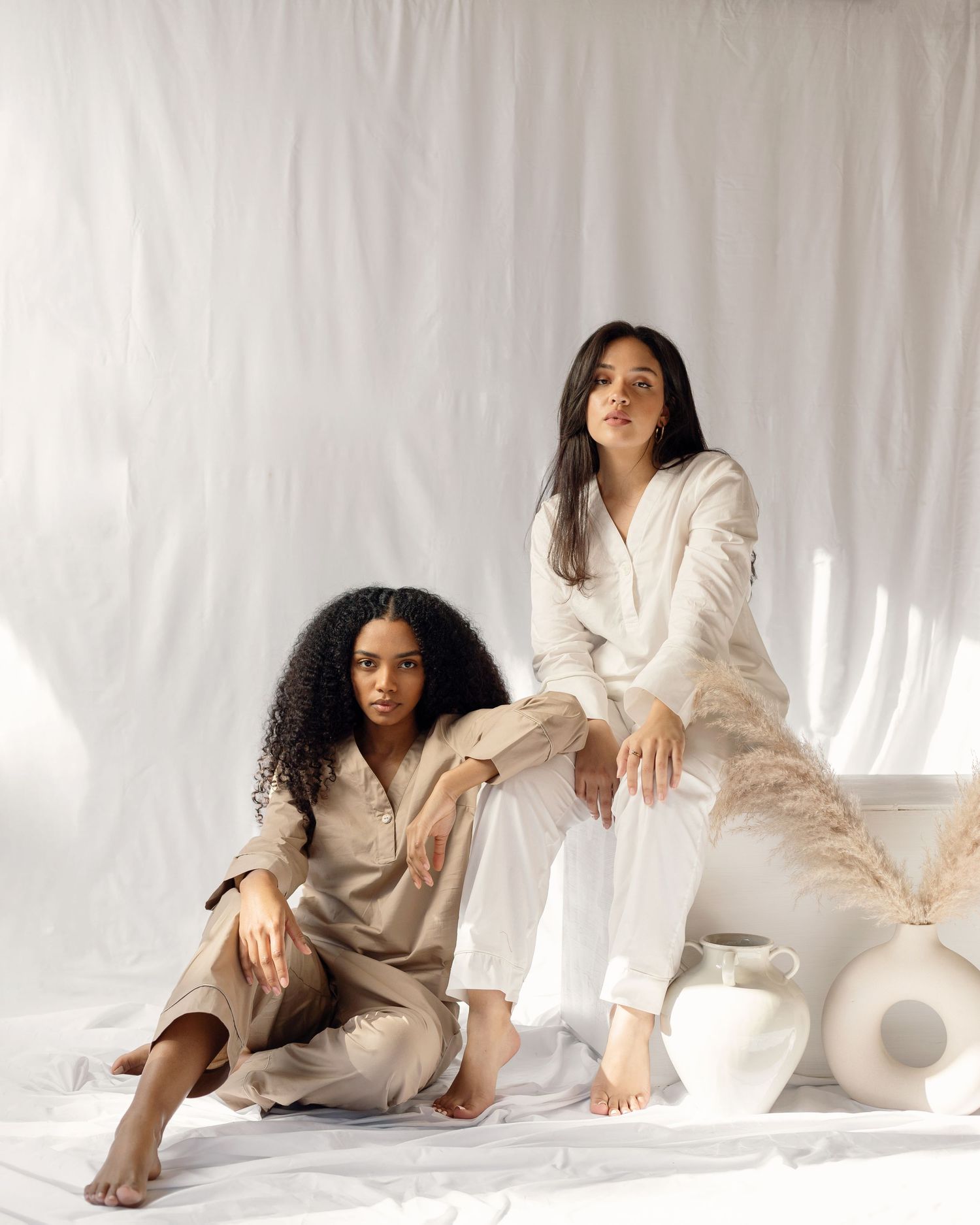 Lifestyle photoshoot featuring cozy loungewear in neutral tones against white backdrop.