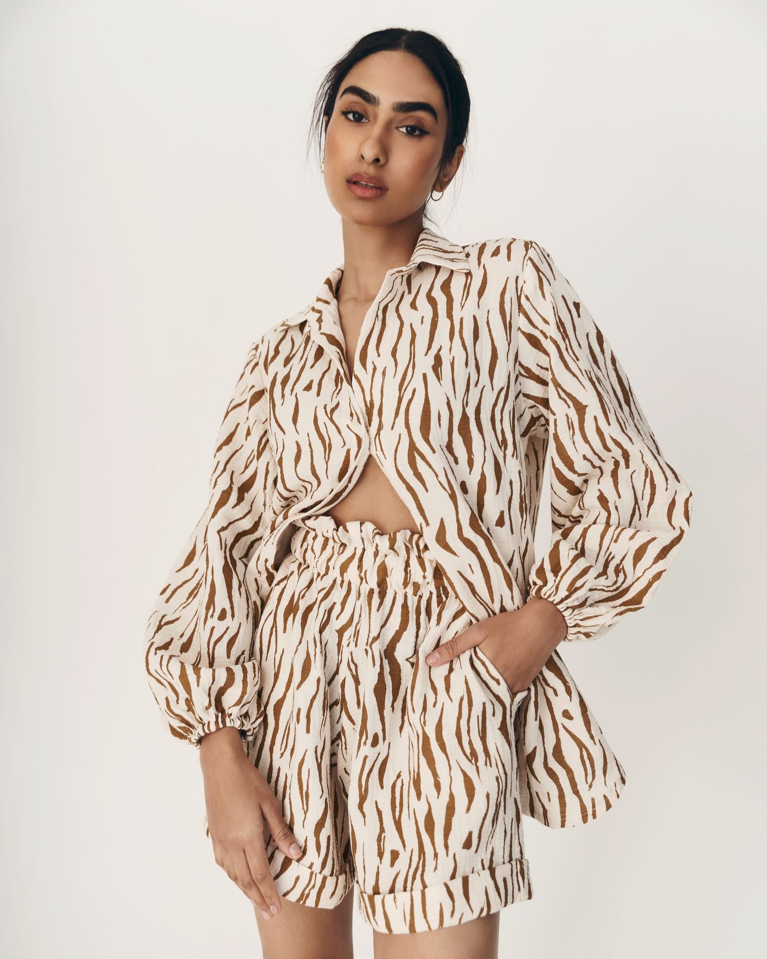 Fashion model wearing a stylish brown and white zebra print matching set with cropped top and shorts.