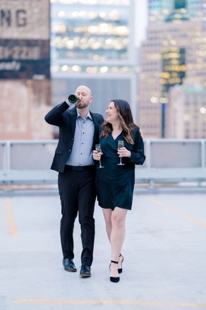 Pittsburgh engagement photographer on city rooftop with champagne
