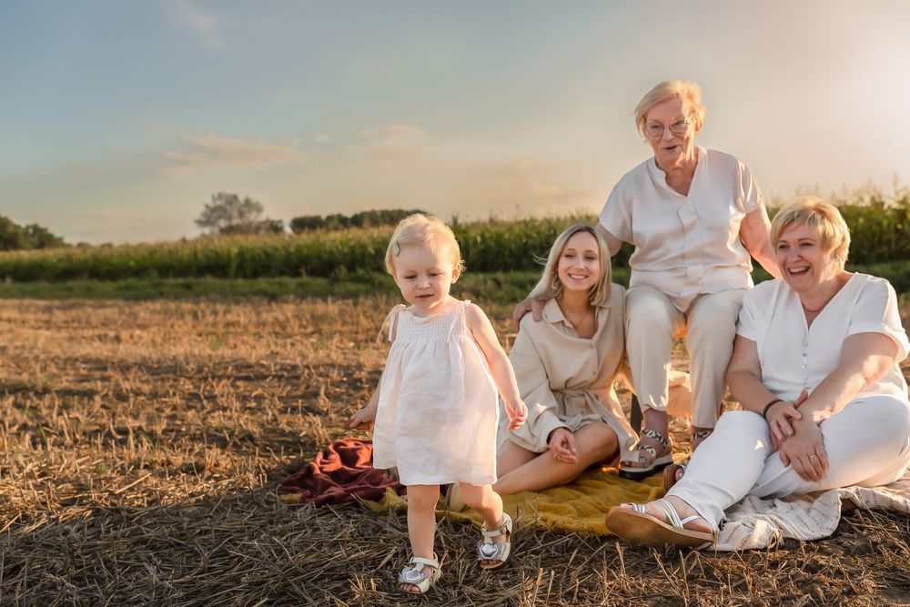 A heartwarming family moment captured at sunset in a field with coordinated white outfits.