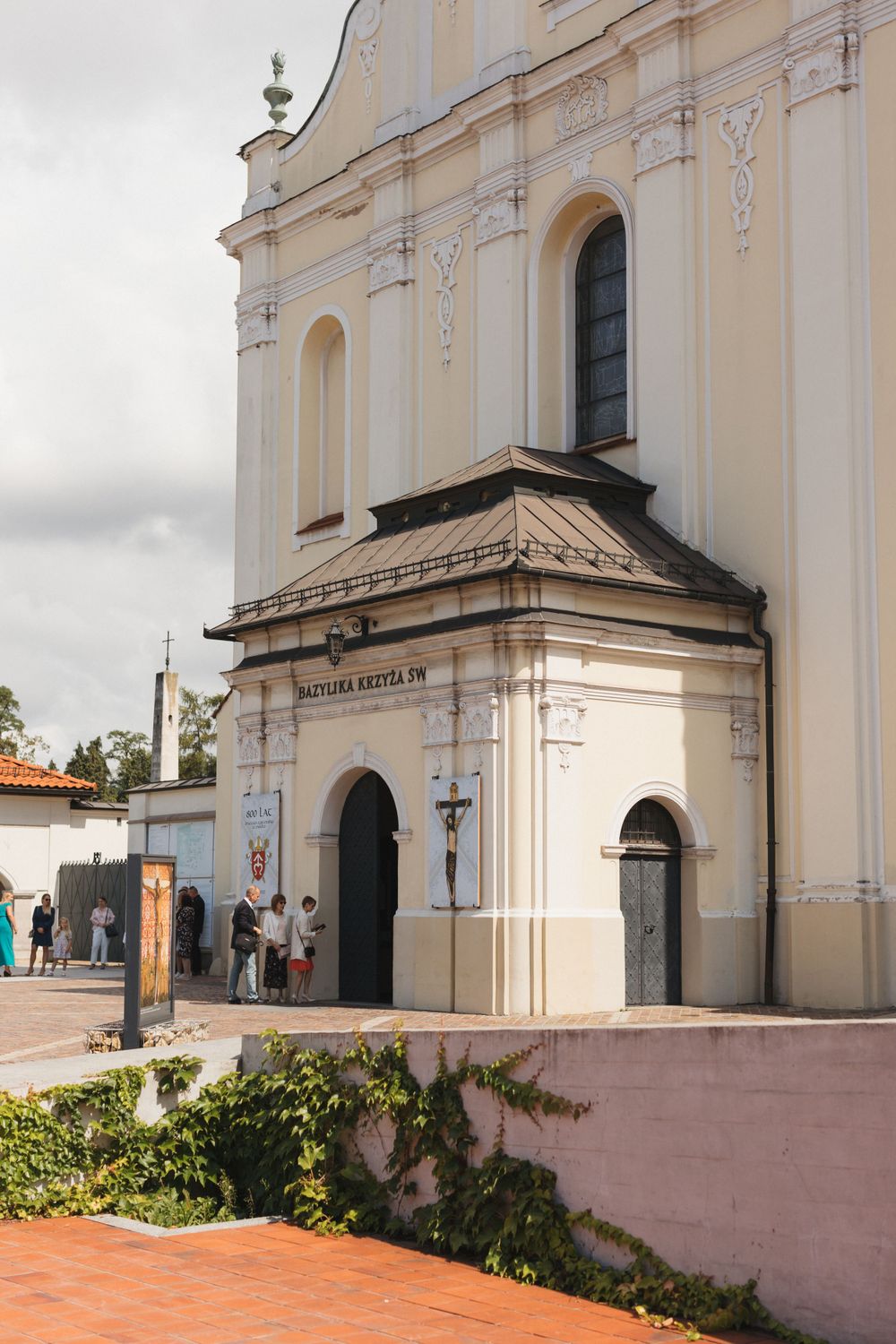 White baroque church exterior with arched entrance and ornate facade details.