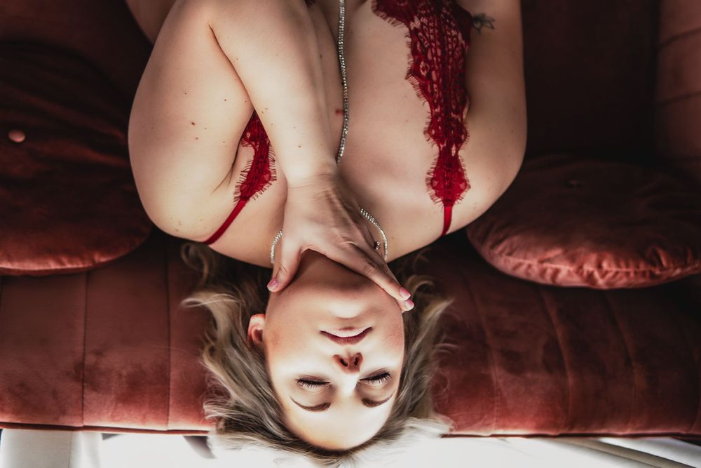 woman grabbing her neck and leaning back on the couch for an intimate boudoir session