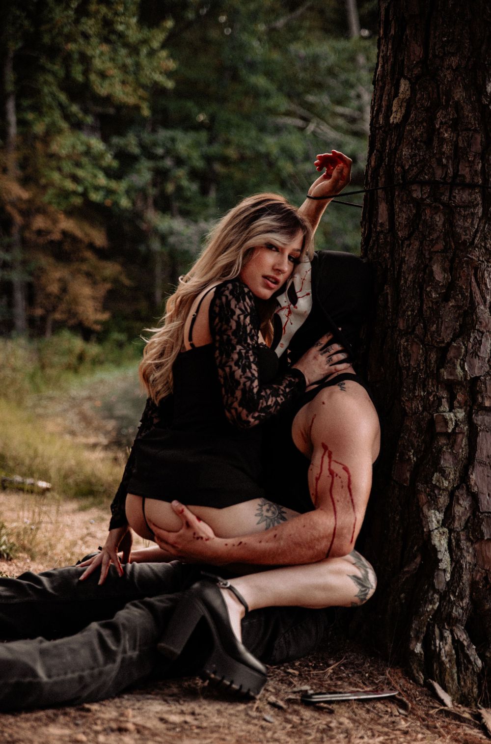 Intimate couples portrait session against a tree in natural forest lighting.