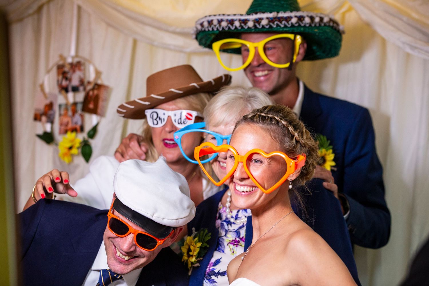 Wedding guests wearing colorful novelty party glasses pose for fun photos at the reception.