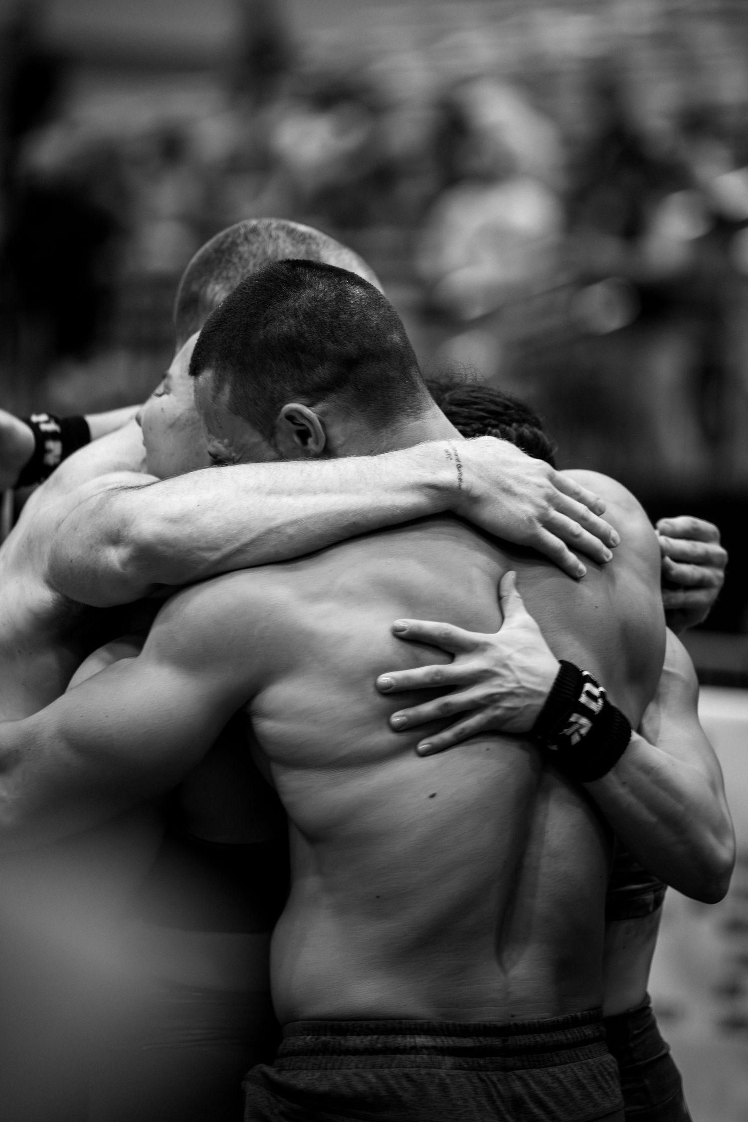 Two athletes embrace in an emotional moment after competition, showcasing raw emotion and sportsmanship.