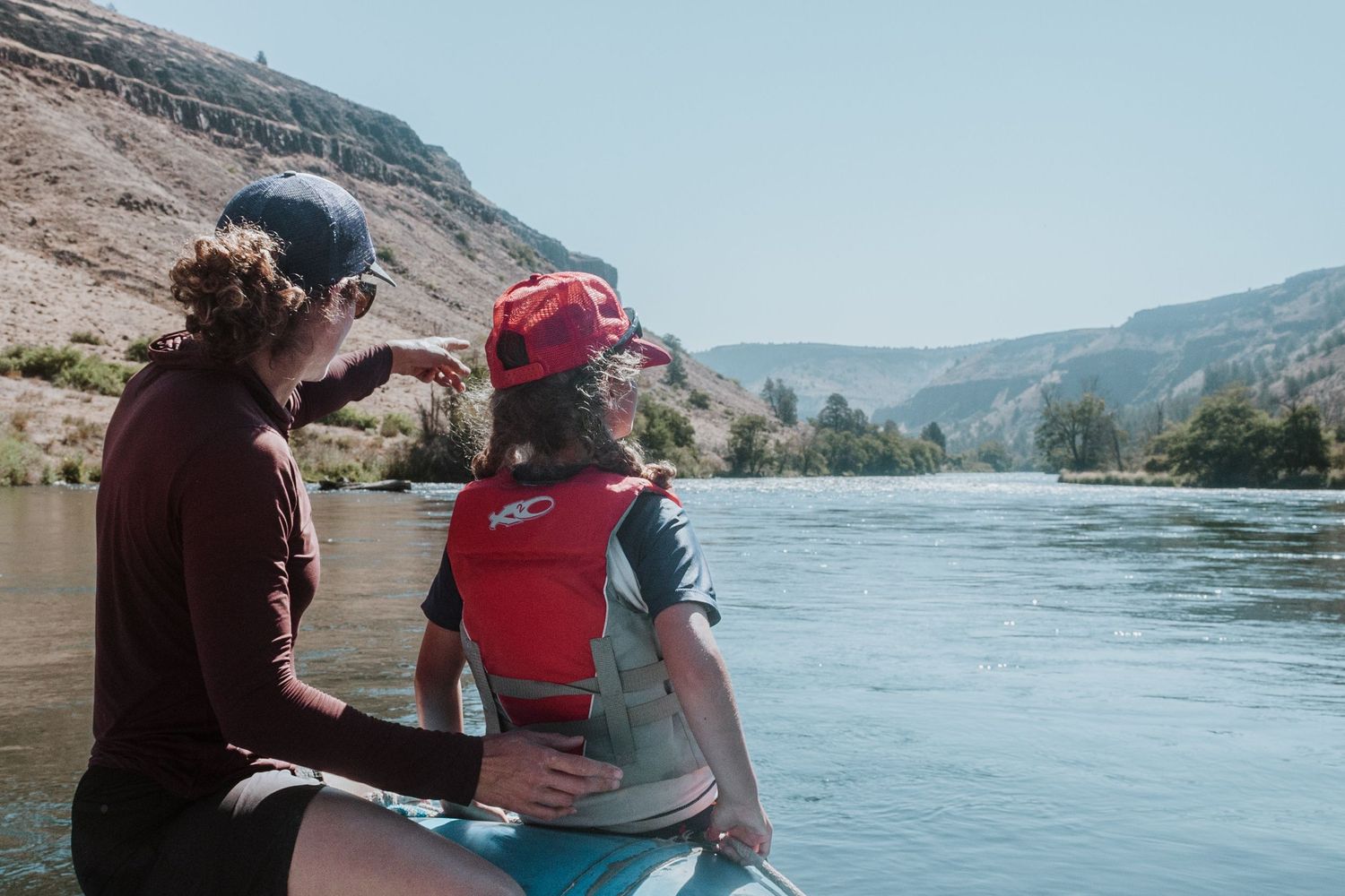 Mother pointing down river with daughter on a float trip on the Deschutes River, Oregon