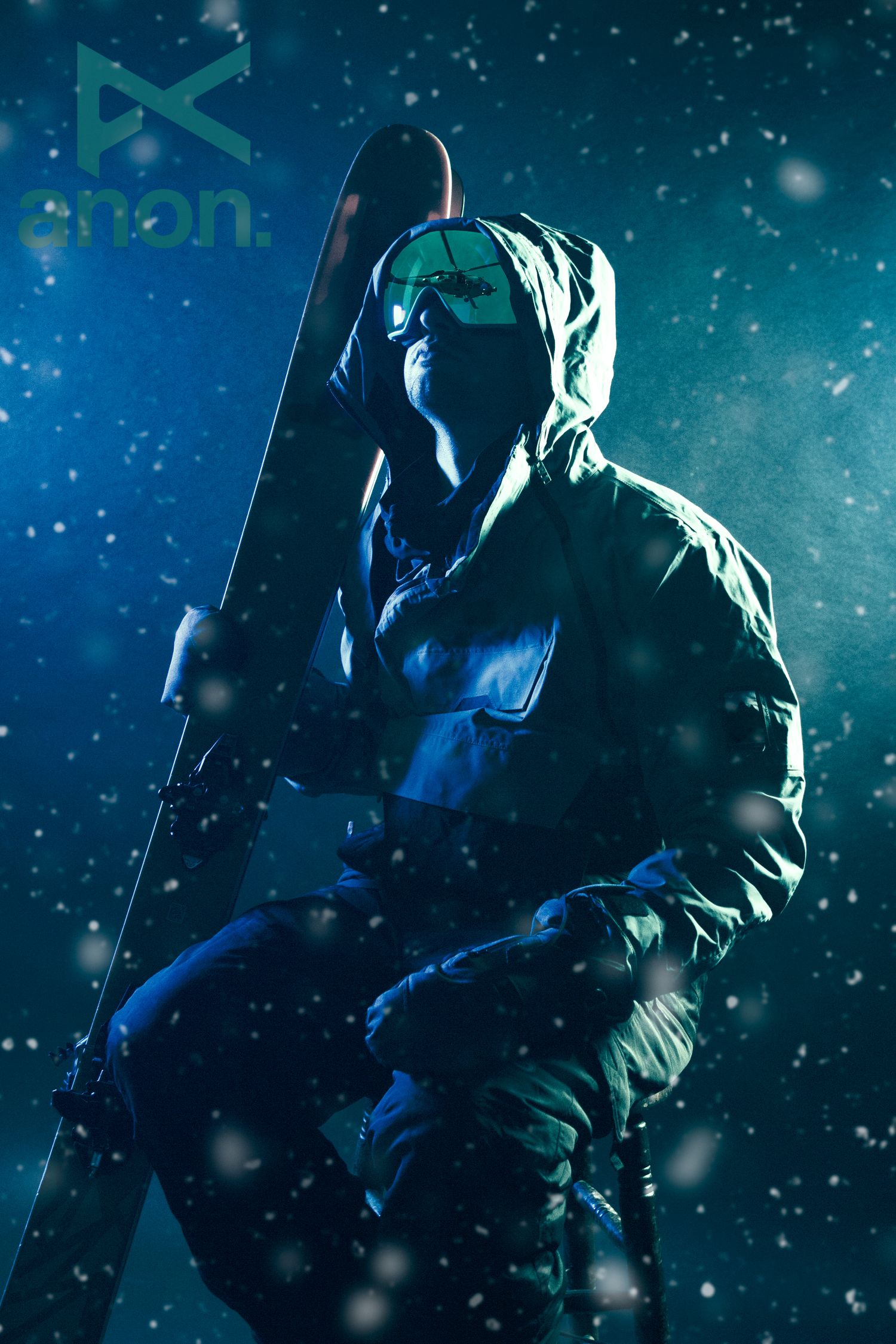 Dramatic silhouette of a skier against snowy night sky with turquoise lighting effects.