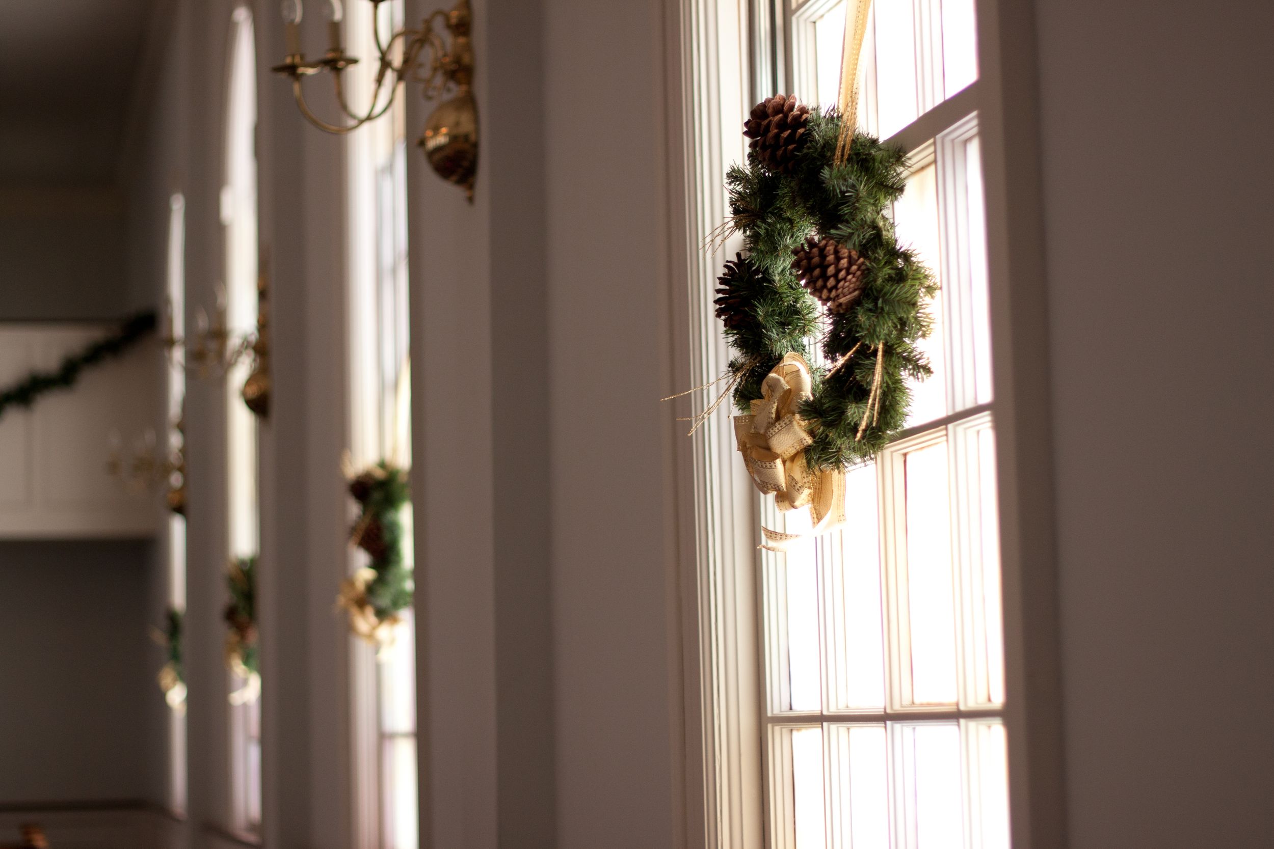 Church interior decorated with holiday greenery and natural light streaming through windows.