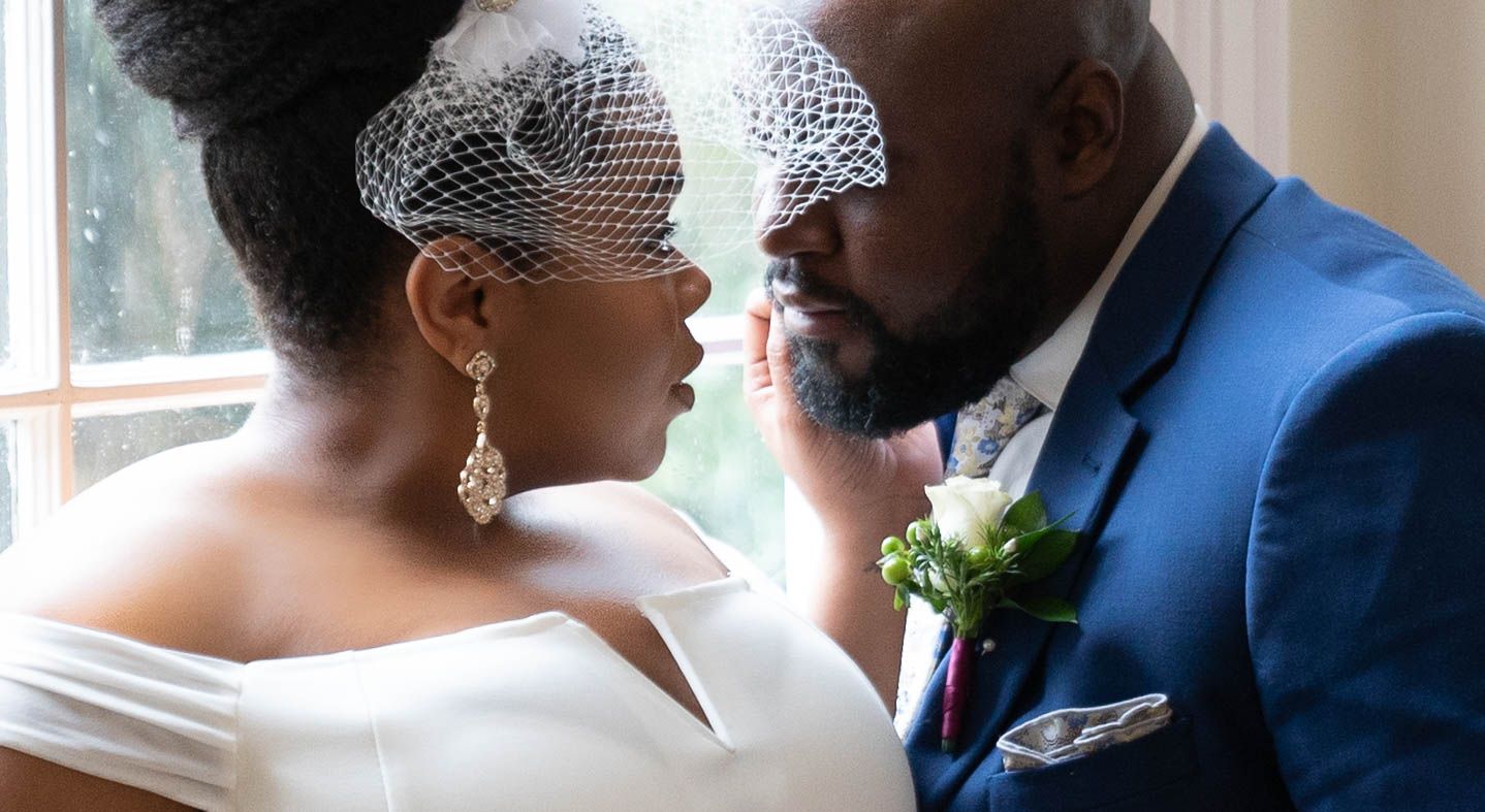 An intimate wedding portrait moment photographed in natural window light.