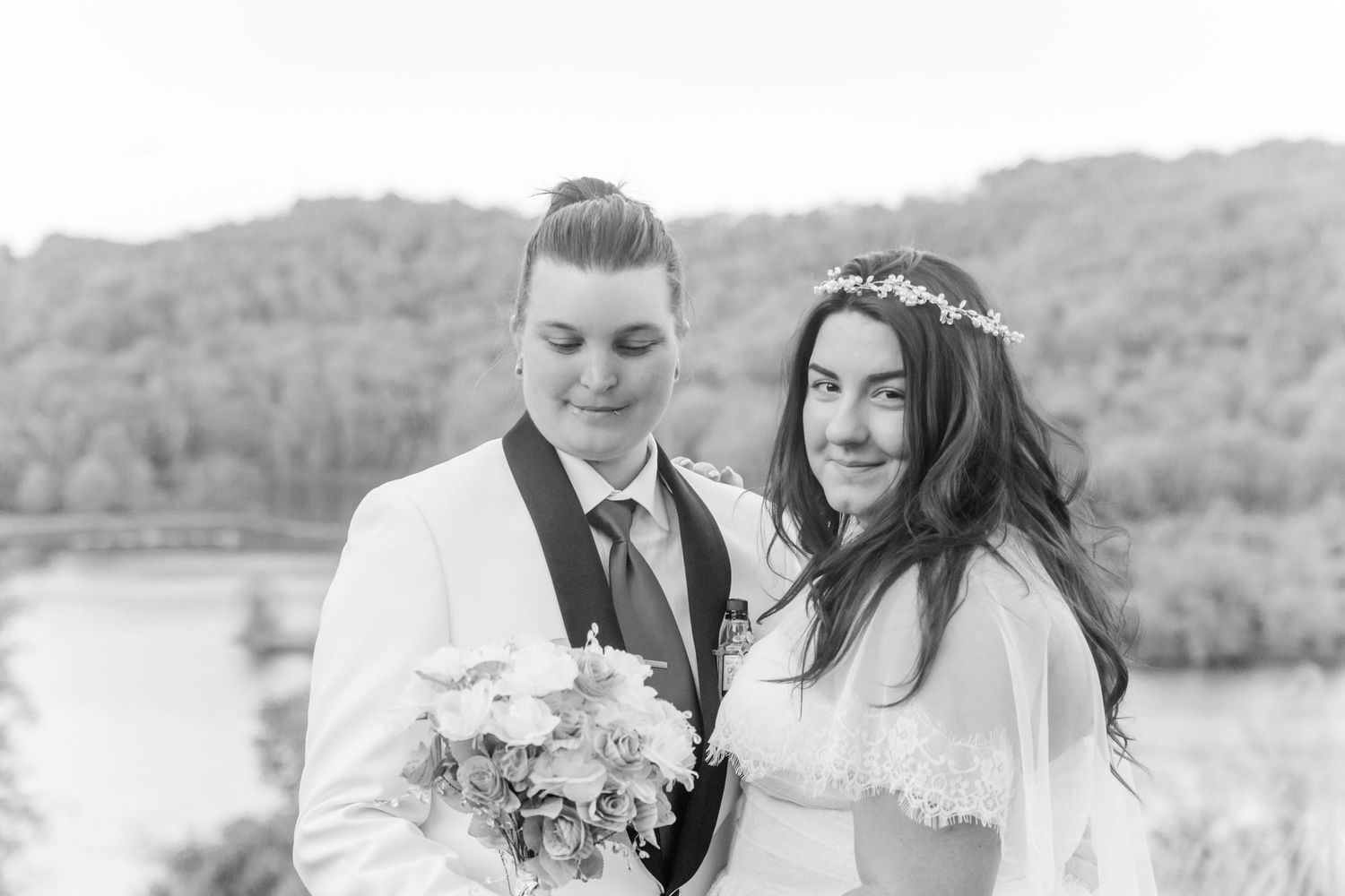 Black and white wedding portrait with scenic mountain backdrop.