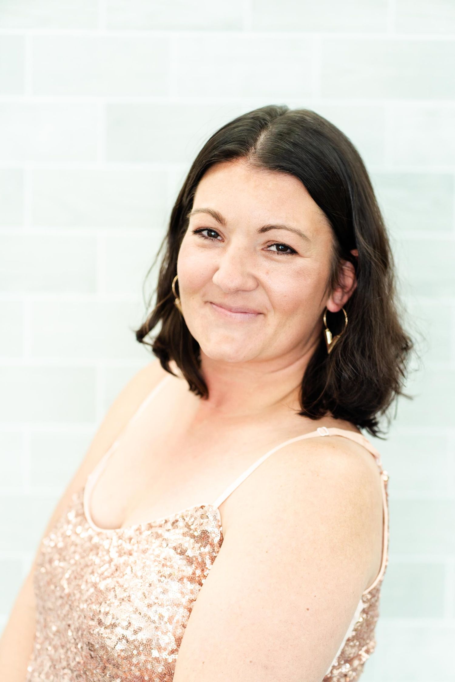 Person wearing sparkly champagne top photographed against white background.