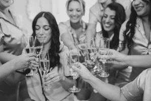 Friends toasting with champagne glasses in black and white celebration photo.