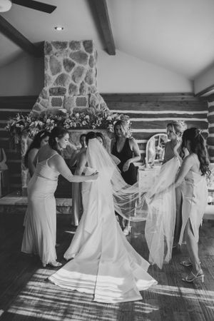 Wedding celebration in a rustic cabin interior with stone fireplace.