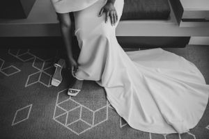 Black and white photo of wedding dress train on geometric patterned carpet.