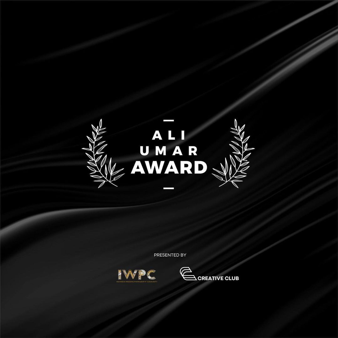 Black award logo design with laurel wreath on dark textured background.