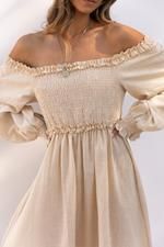 A row of white maternity dresses with delicate lace and ruffle details hanging on display.