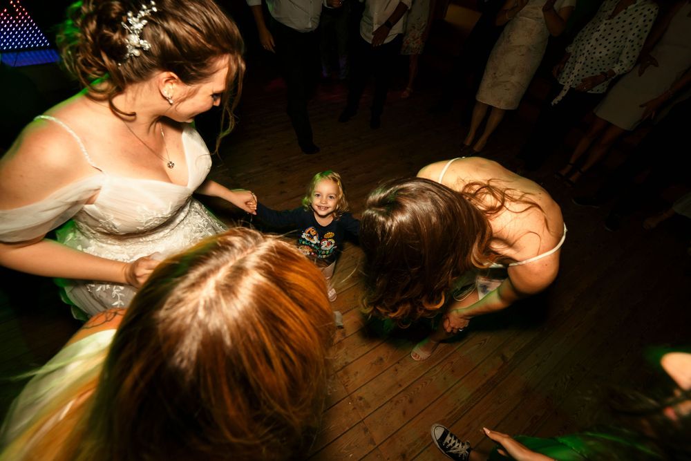 Lively dance floor moment during wedding reception with guests enjoying festivities.
