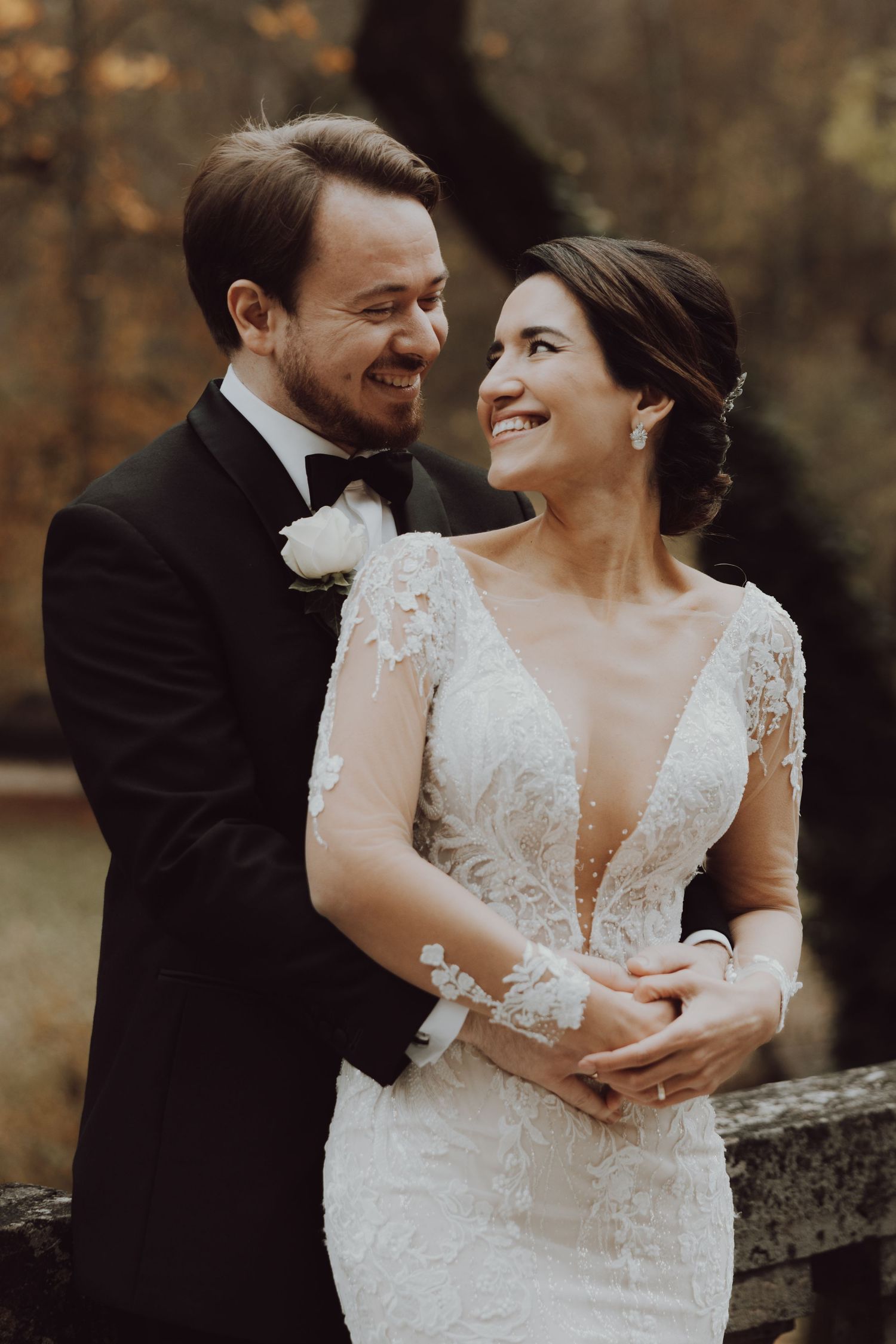 An intimate wedding portrait captured outdoors during autumn with soft natural lighting.