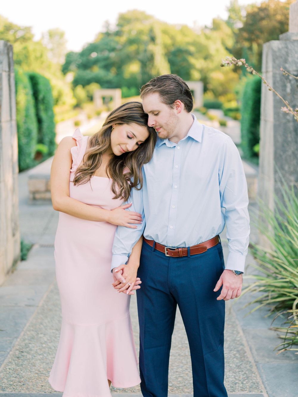 engagement session of a couple holding hands in a garden