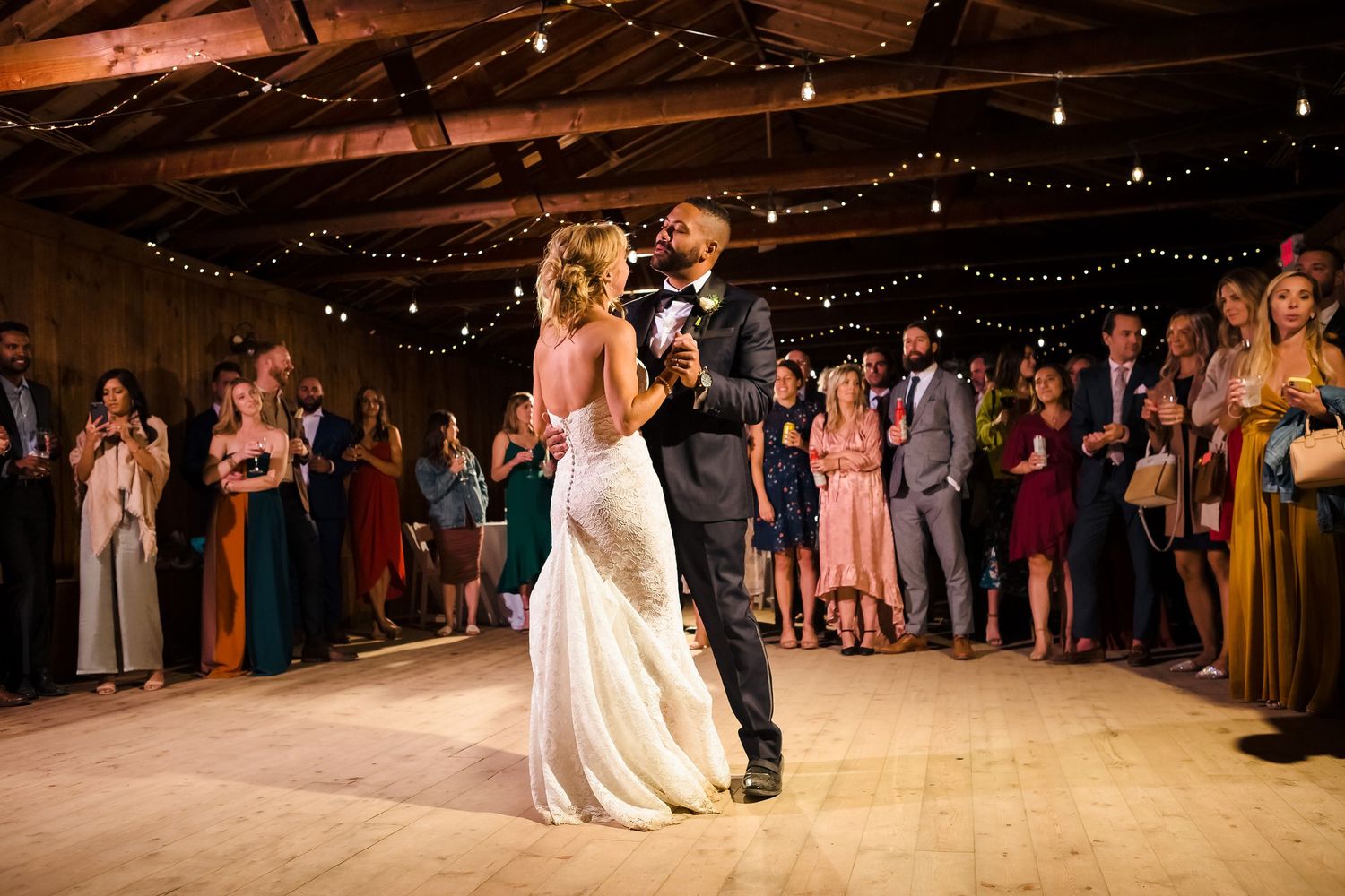 Bride and groom enjoying their first dance as man and wife with all their guests watching.