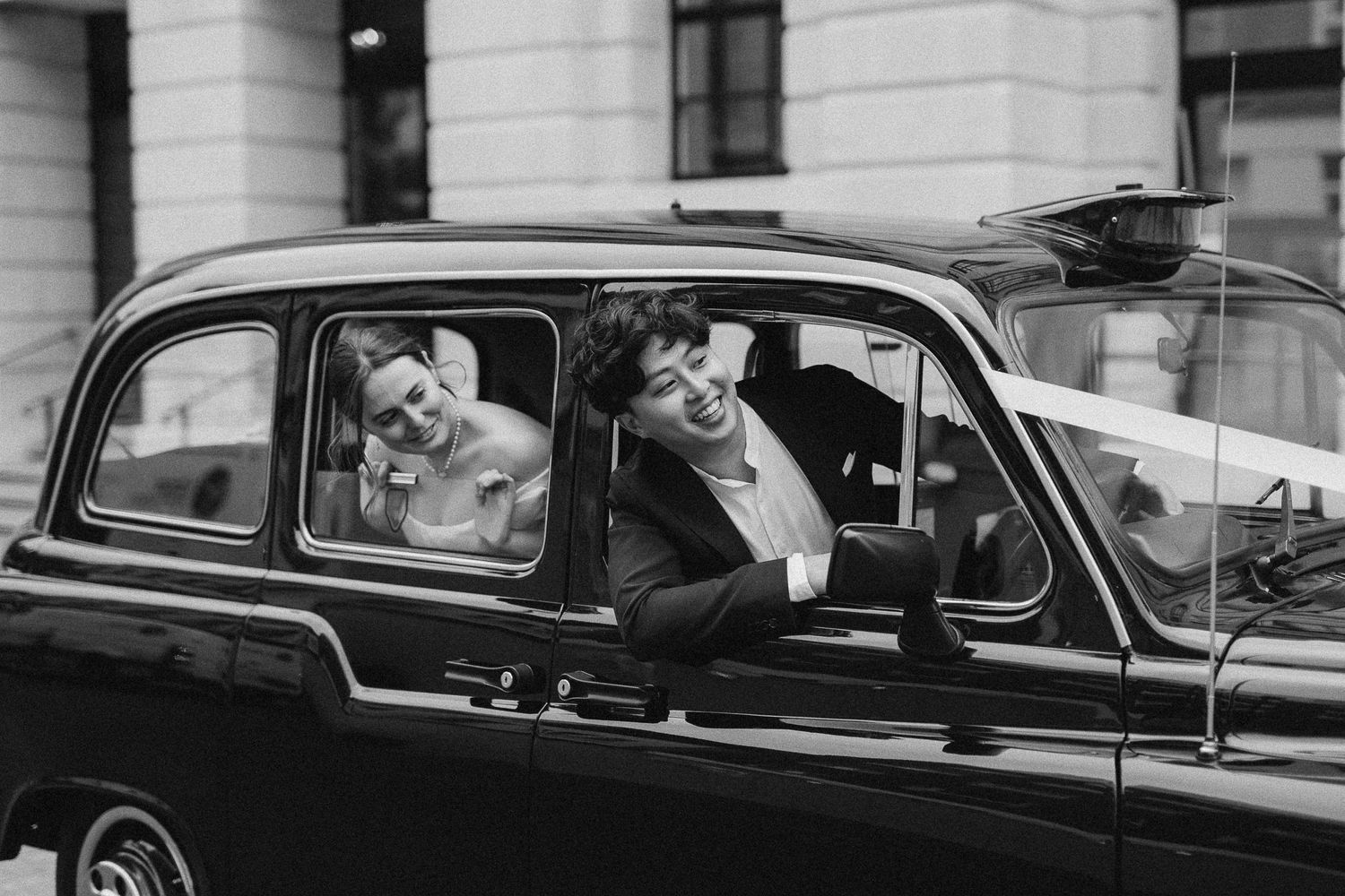 Bride and groom in their wedding car captured by wedding photographer in London, UK