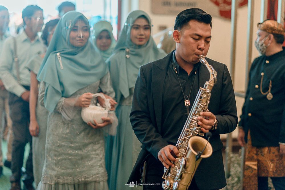 Musicians performing at formal event with saxophone player in formal attire.