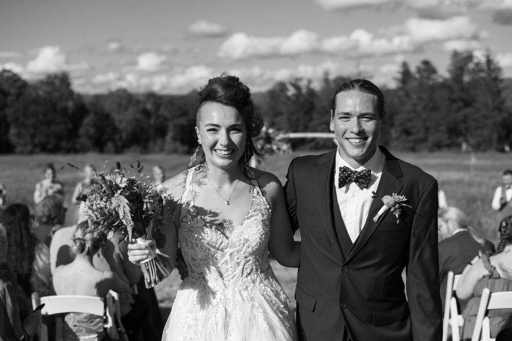 A joyful newlywed couple celebrates after their outdoor wedding ceremony.