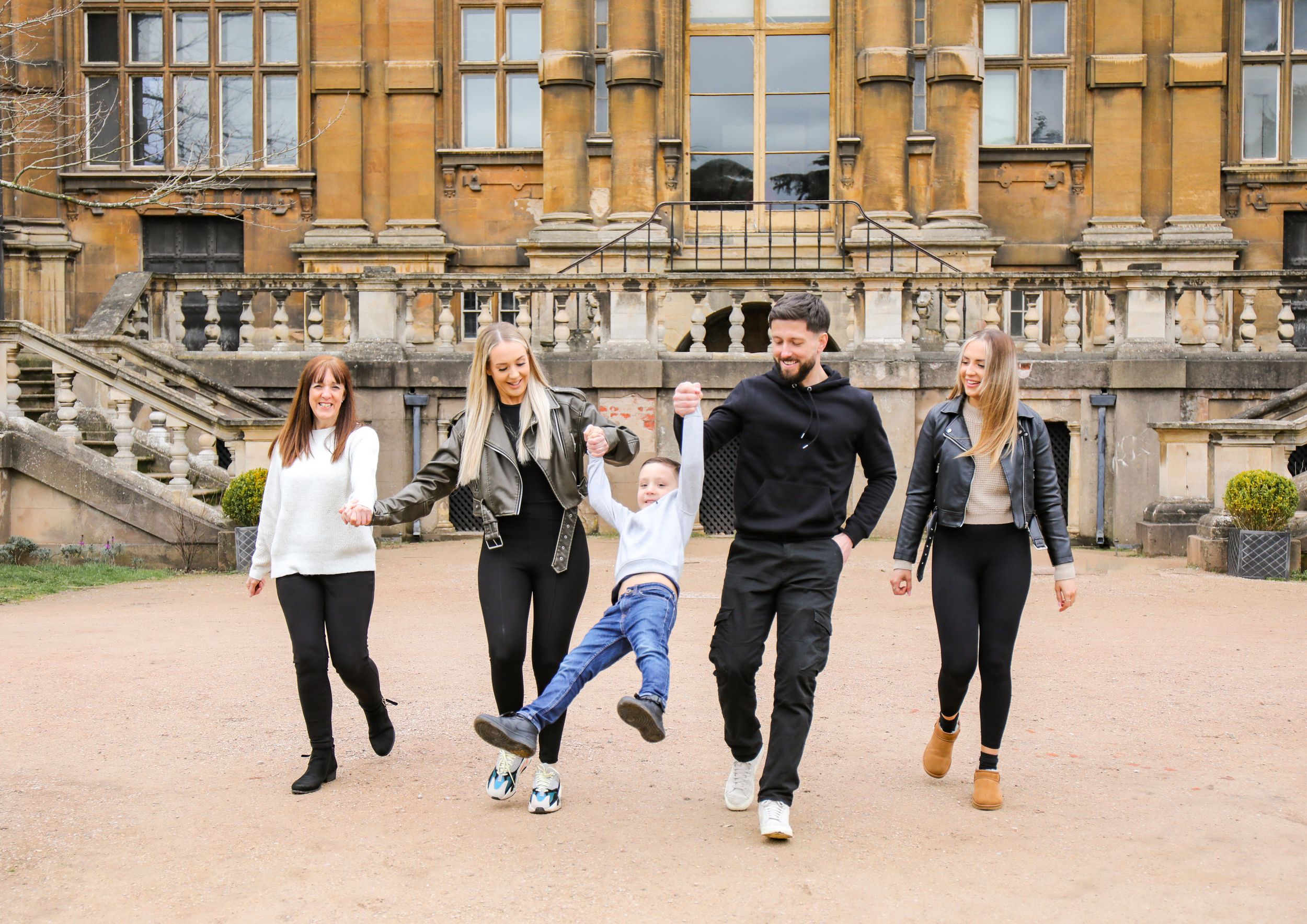 A playful group enjoying themselves in front of a grand historic building.