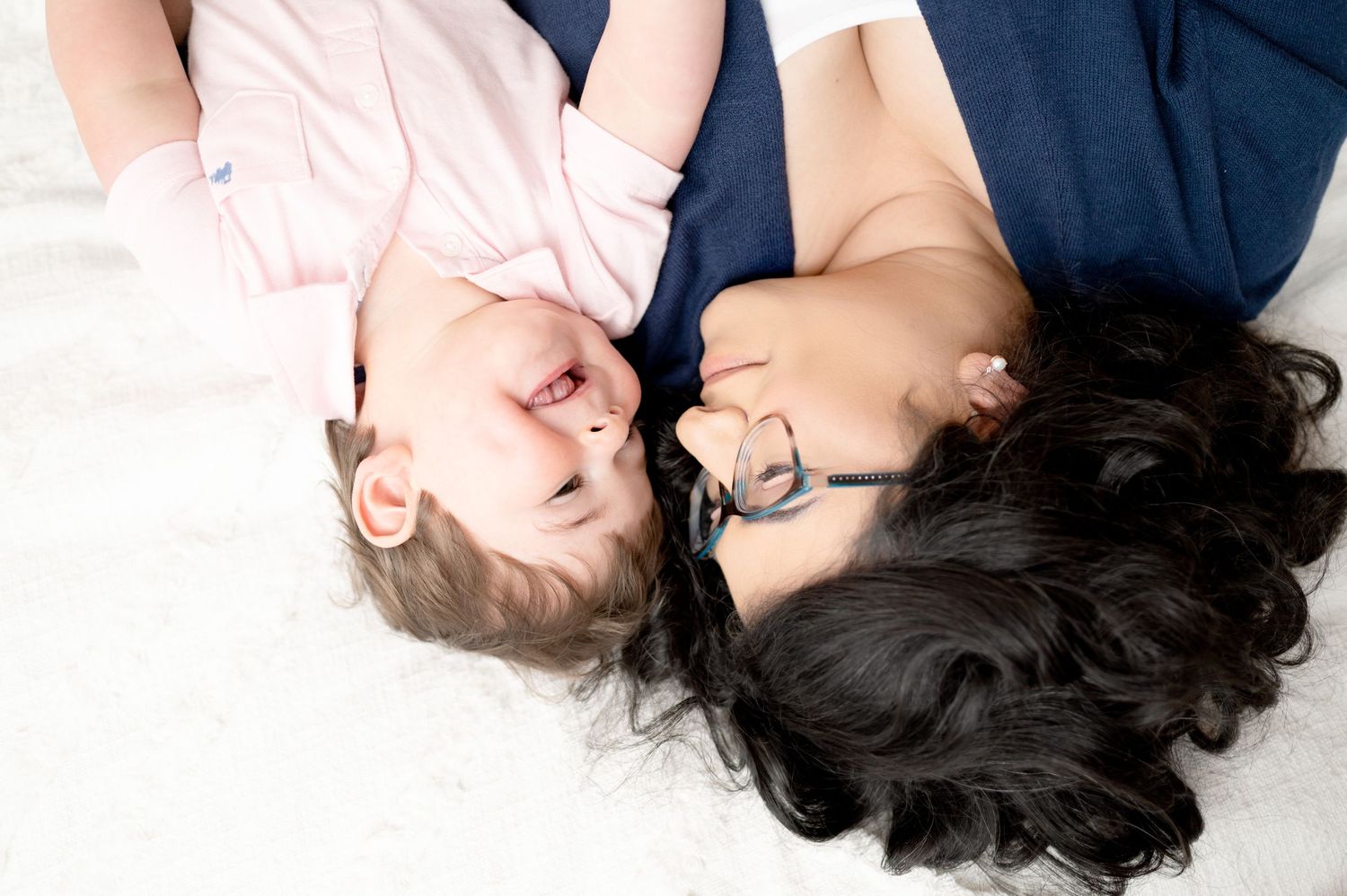 Two people share intimate resting moments on white background.