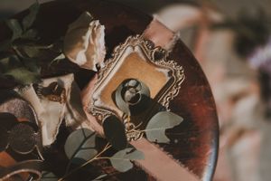 Vintage ornate frame with floral decorations photographed in moody lighting.
