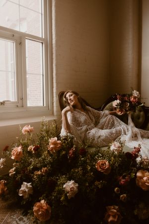A romantic boudoir scene with soft window light and abundant rose arrangements.