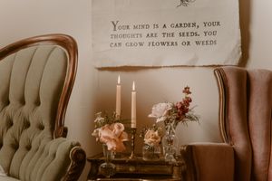 Vintage tufted chairs and candelabra with fresh flowers create a romantic boudoir setting.