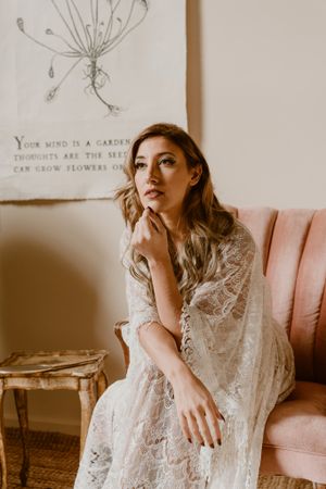 Intimate portrait beside botanical artwork in vintage seating.