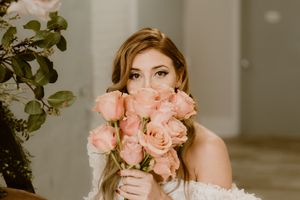 A romantic bridal portrait with peach roses held close to create a floral frame in the Hudson Valley,NY.