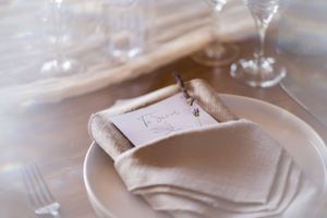 Elegant table setting with folded napkin and place card in soft focus.