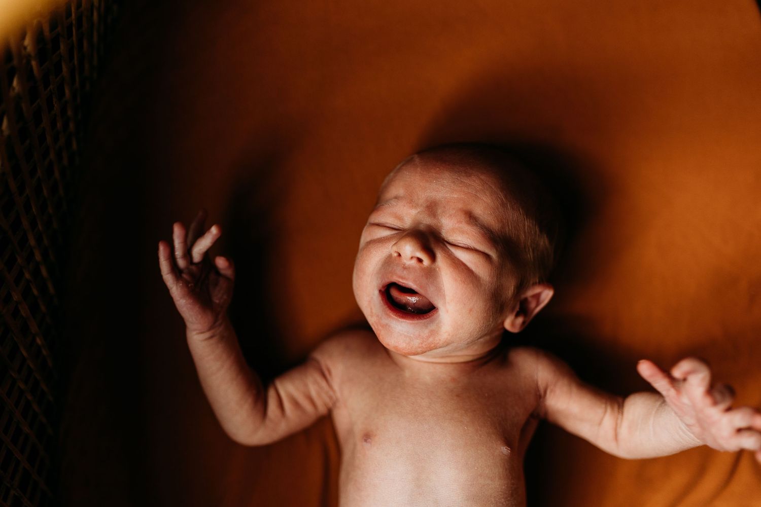 A peacefully sleeping infant lying on an orange-tinted surface.